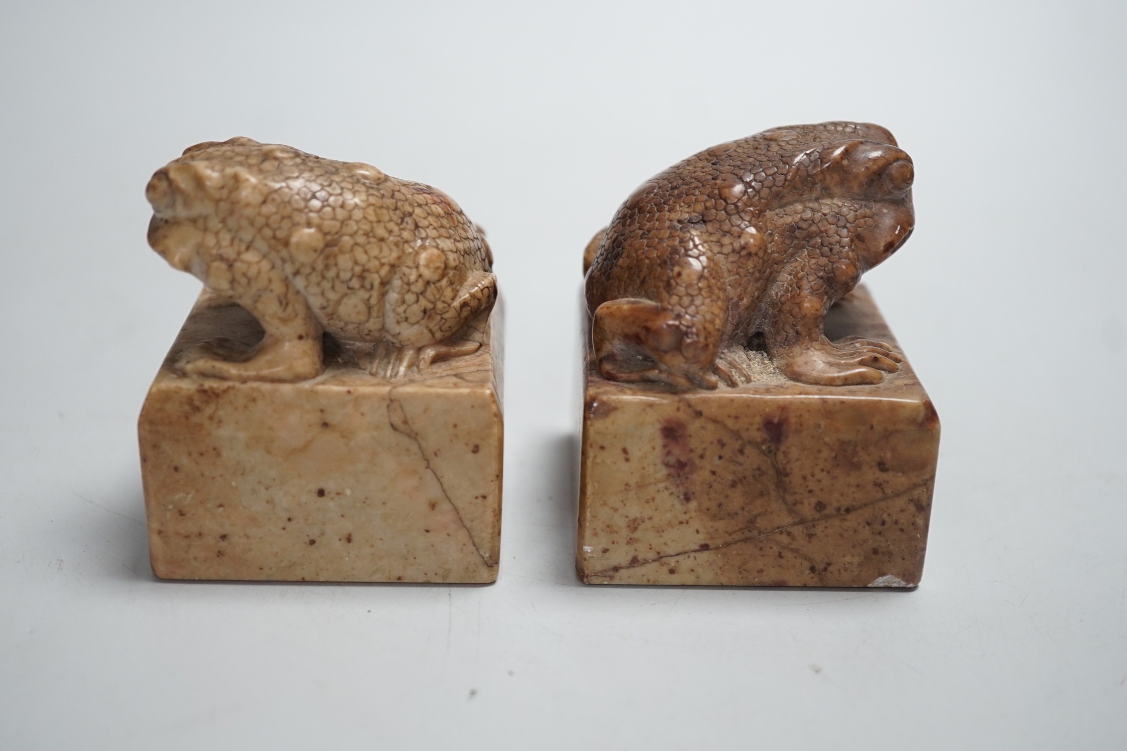 A pair of Chinese carved soapstone chop seals decorated as seated toads, 6cm